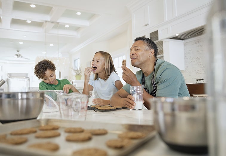 father and his children eating cookies as a family