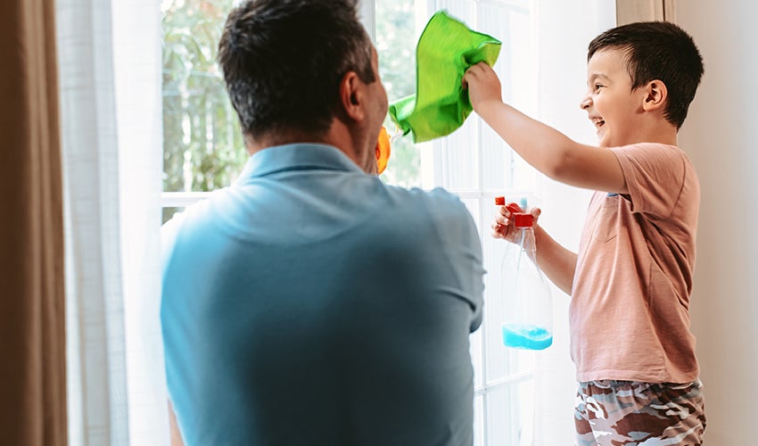 Father and son cleaning window