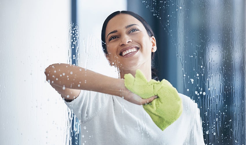 Woman cleaning bathroom screen 