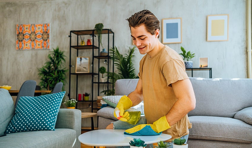 man cleaning living room table